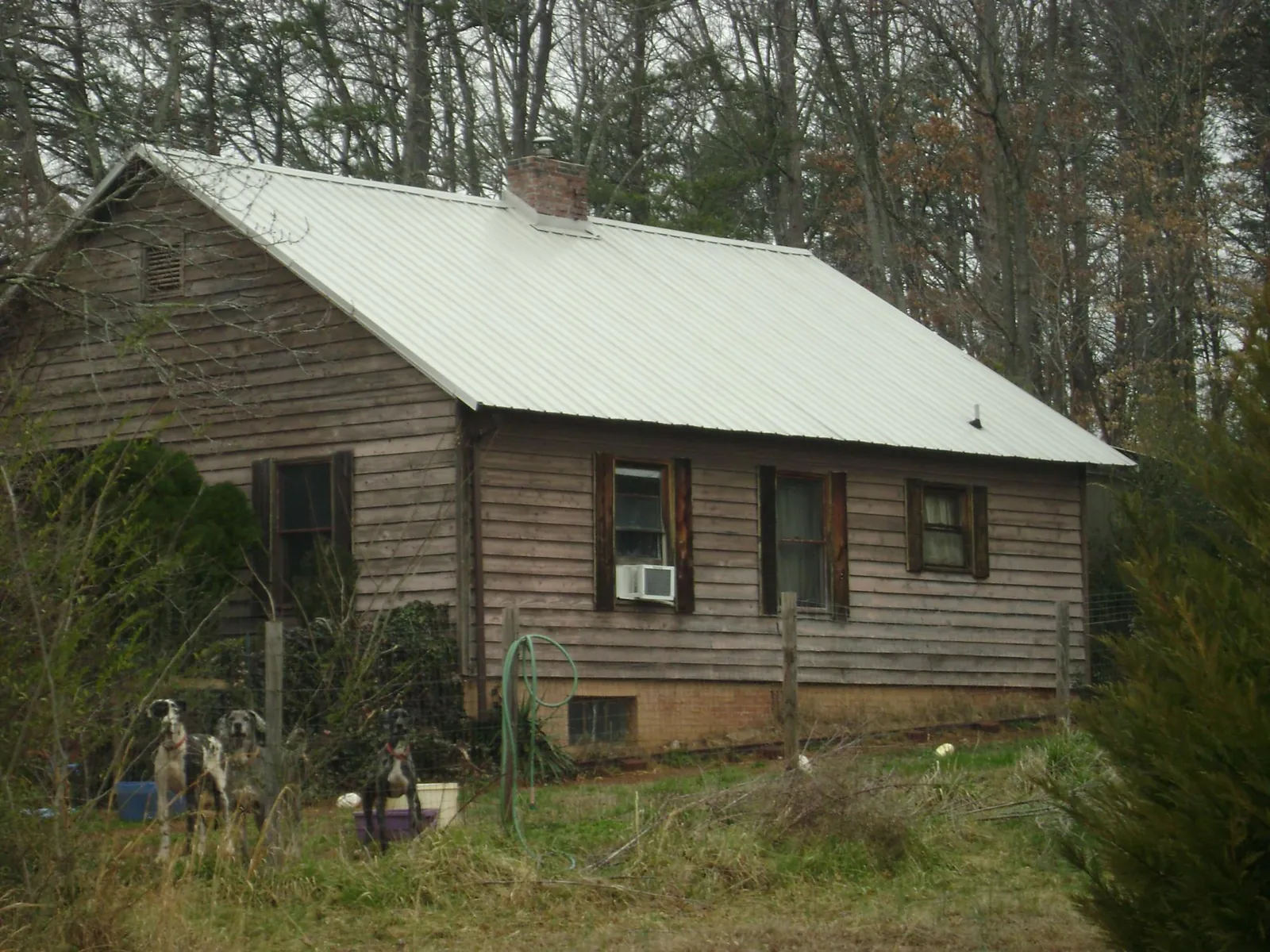 White metal roof on an old wood sided farmhouse, from a Metal Roof Installation job in Rich Hill